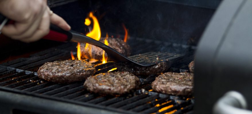 A person grilling hamburgers on a grill